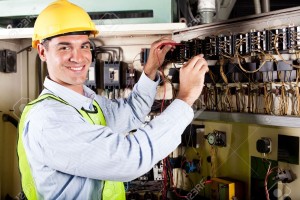 12431712-electricista-hombre-feliz-trabajando-en-maquinaria-industrial-Foto-de-archivo